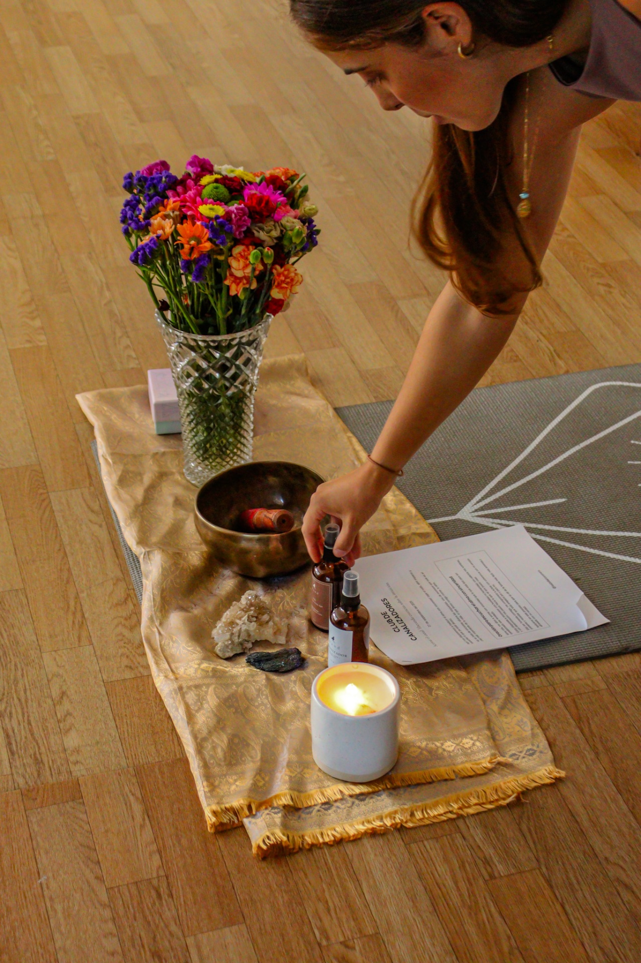 Preparación de un espacio sagrado con cuenco tibetano, velas, flores y cristales